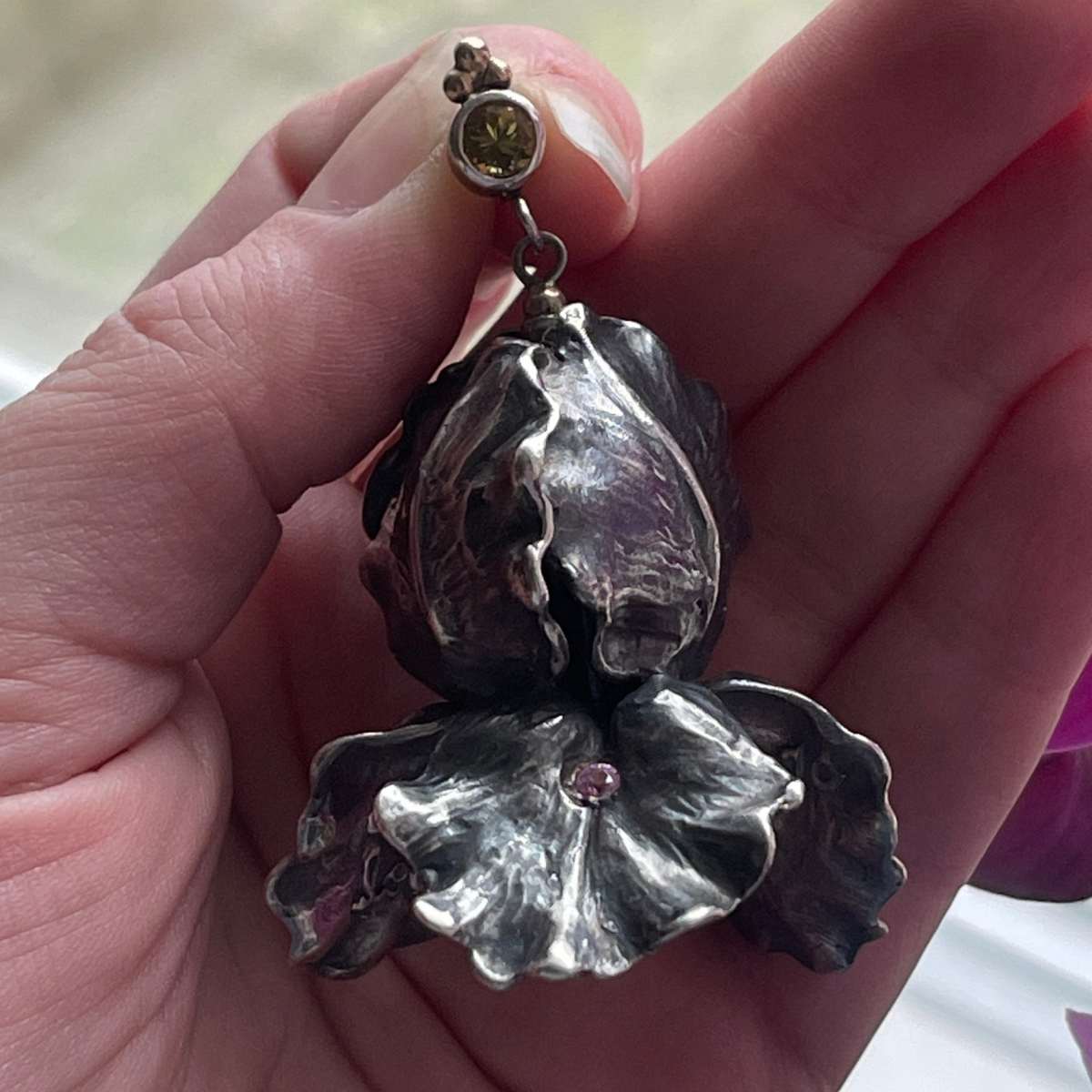 En ørering formet som en blomst i sølv