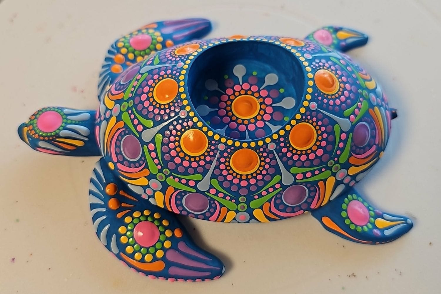 Farverige dotting-mønstre lavet med prikteknik på en skildpadde lysestage