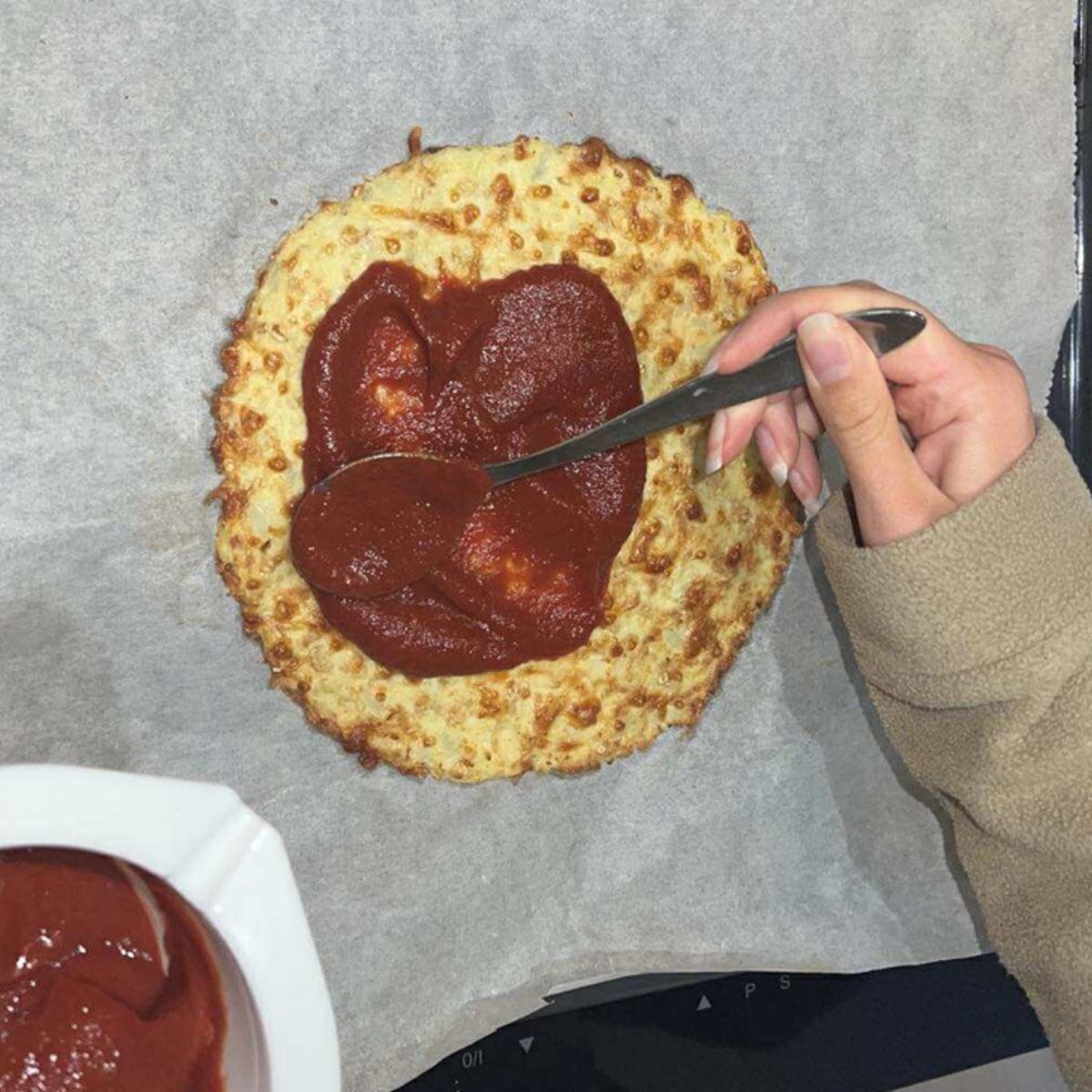 Tid til tomatsovs – den sprøde bund smøres med et lag fyldig tomatsovs.