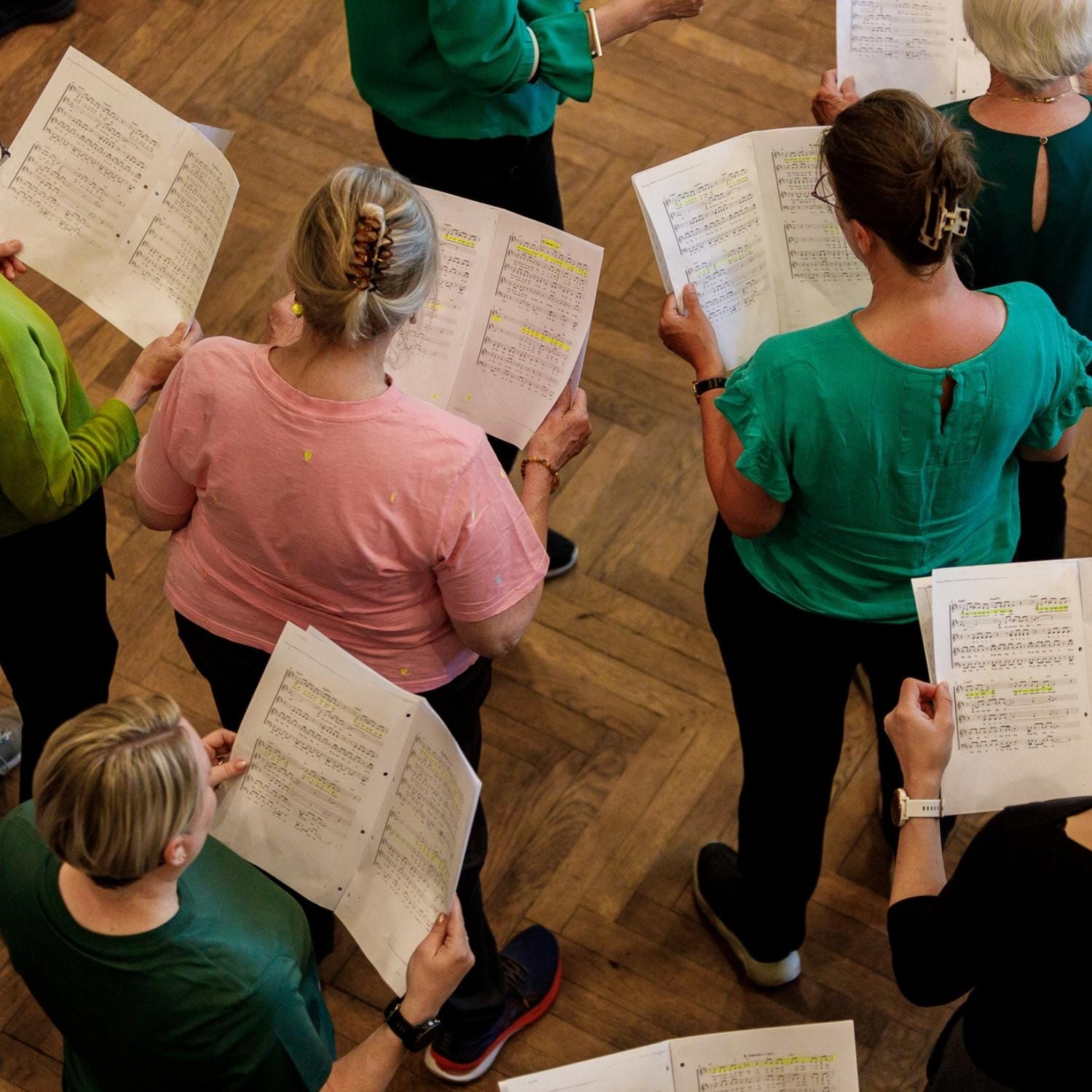 Korets medlemmer der øver sang i deres stemmegruppe