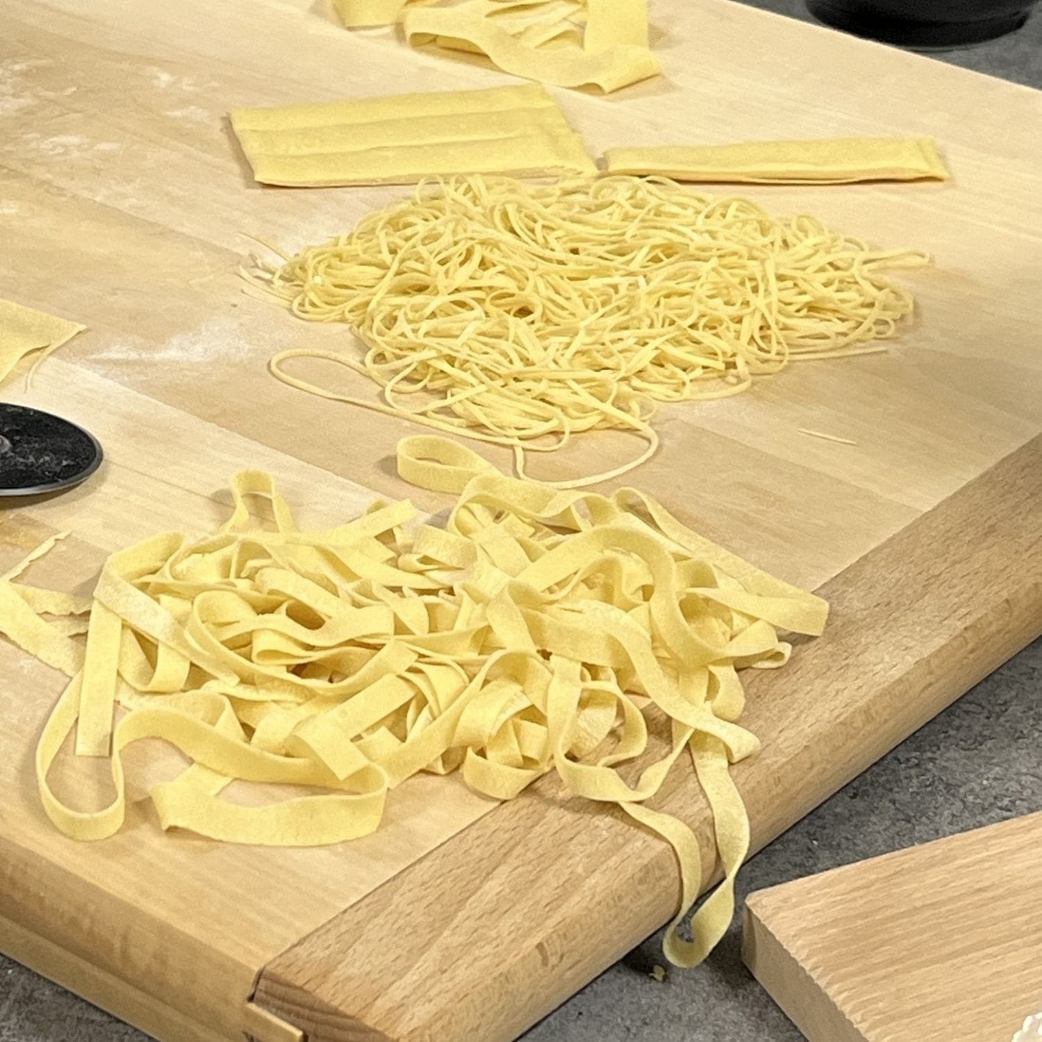 Forskellige typer italiensk æggepasta på et skærebræt