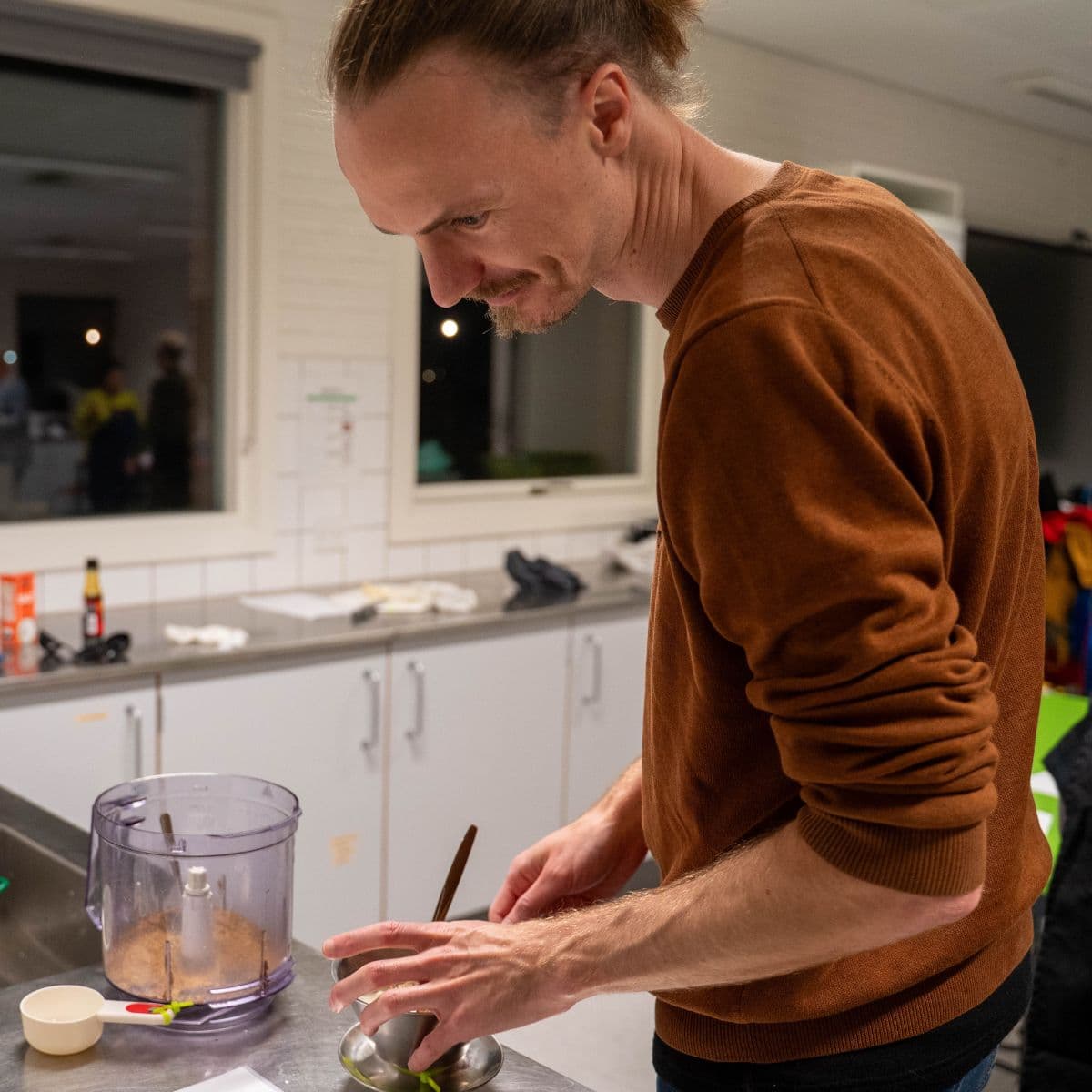 Ramen madkursus. Deltager er i gang med at blande ingredienser i køkkenet.
