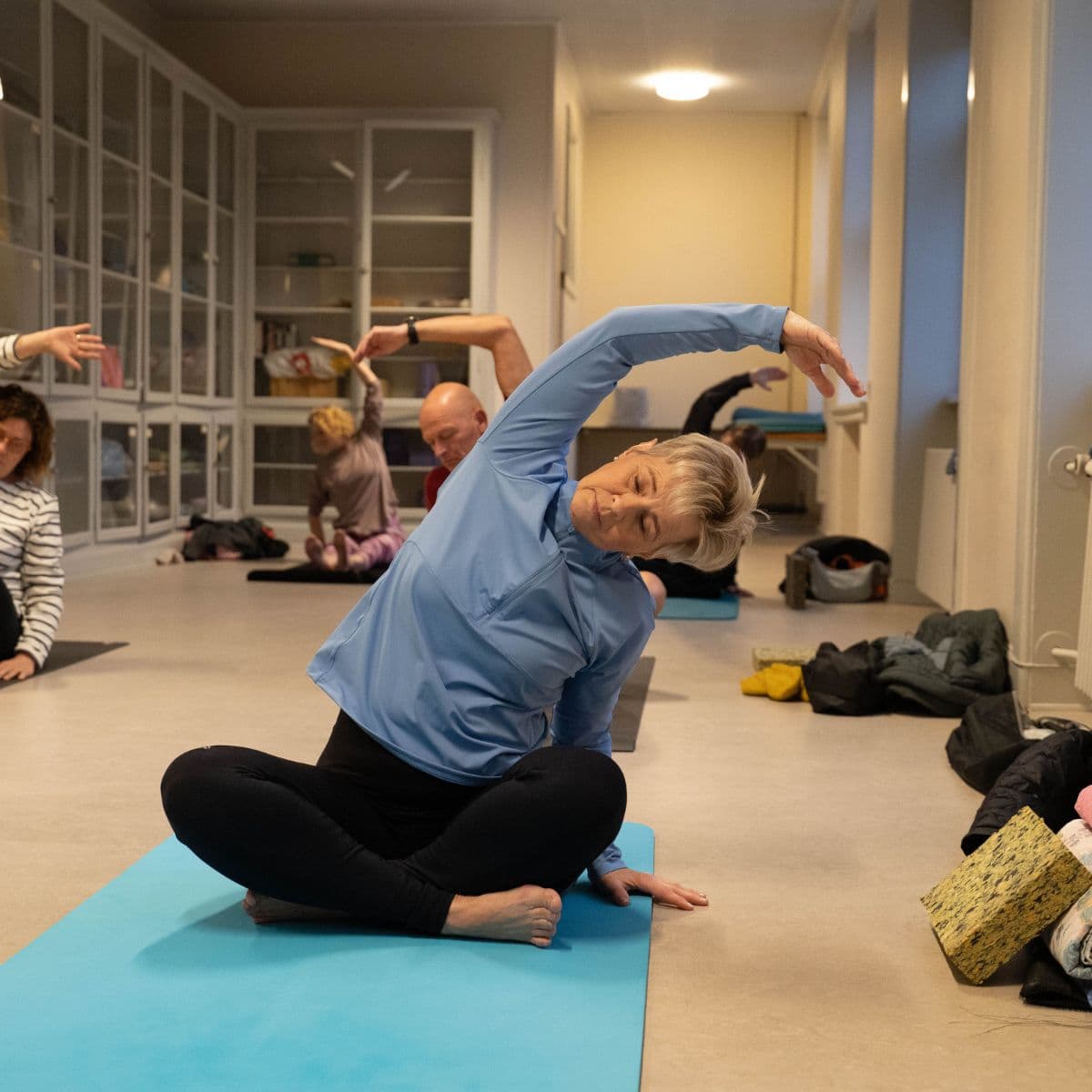 Hatha yoga - deltager laver øvelse på gulvet.
